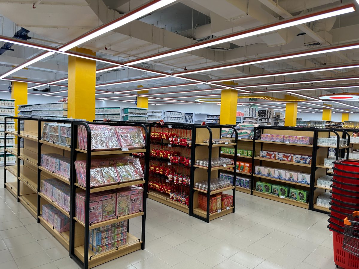 Wide shop aisles lined with fully stocked shelves and shopping baskets